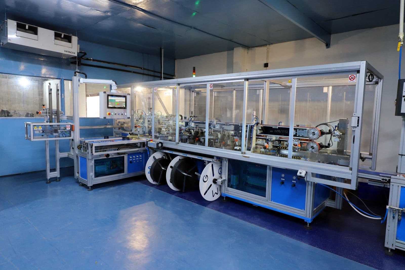 Enclosed automated assembly cell with feed reels